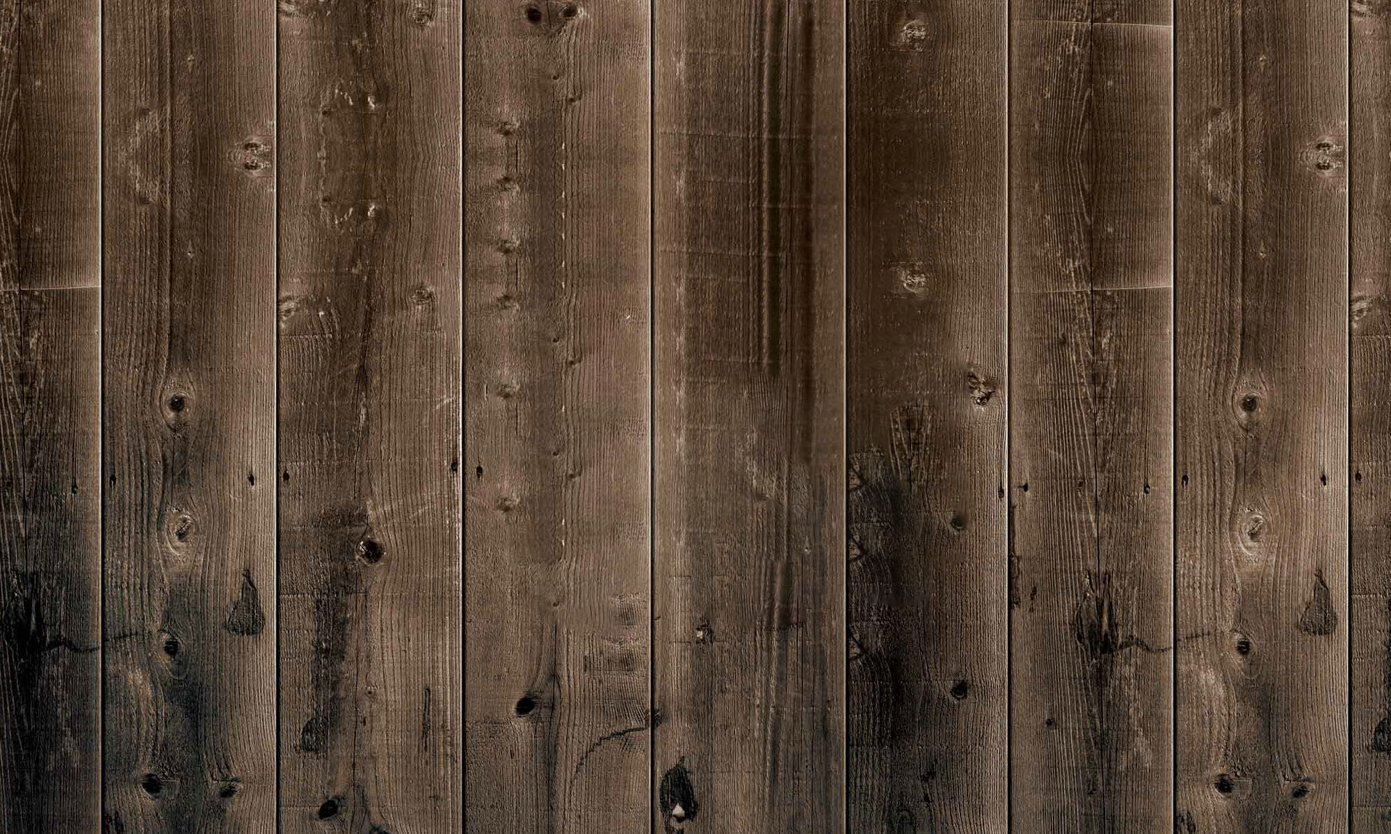 The dark vertical wooden boards of a farmhouse.